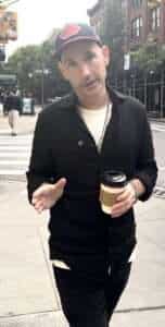 John Keegan walking in NYC with coffee – Dating Coach NYC