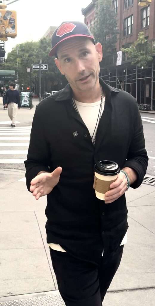 John Keegan walking in NYC with coffee – Dating Coach NYC