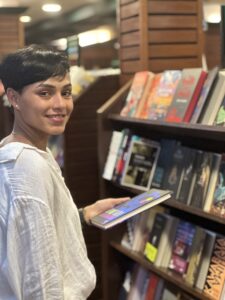 Woman smiling while browsing books in a NYC bookstore

