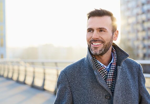Happy man standing outdoors during sunny winter day